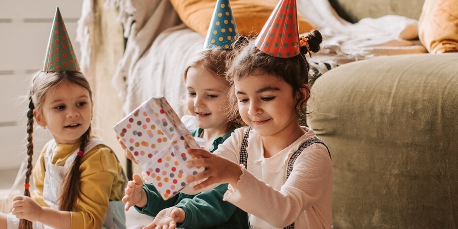 children at a party passing around a wrapped gift