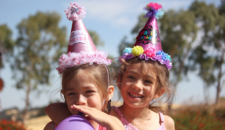 two children in party hats celebrating a birthday
